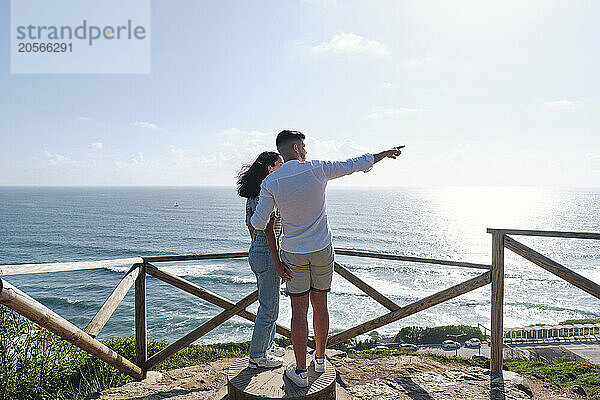 Boyfriend and girlfriend looking at sea