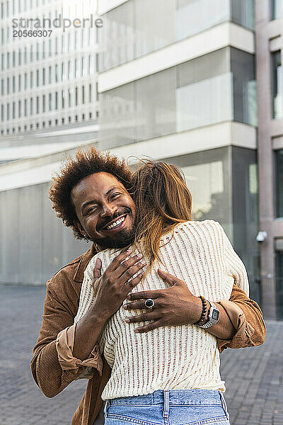 Smiling man embracing girlfriend