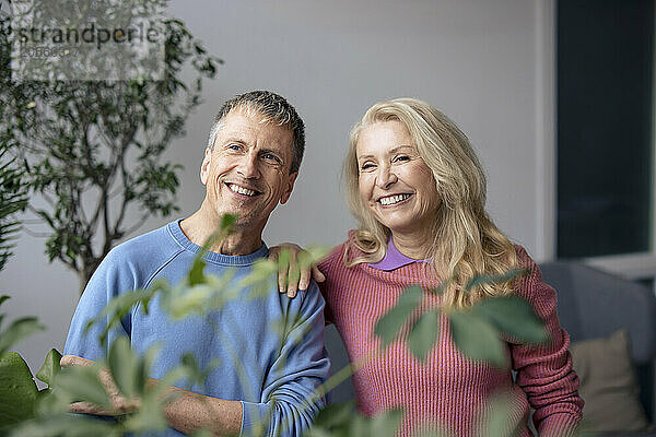 Smiling senior couple looking away at home