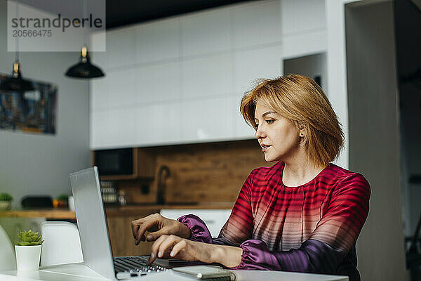 Businesswoman typing on laptop in home office