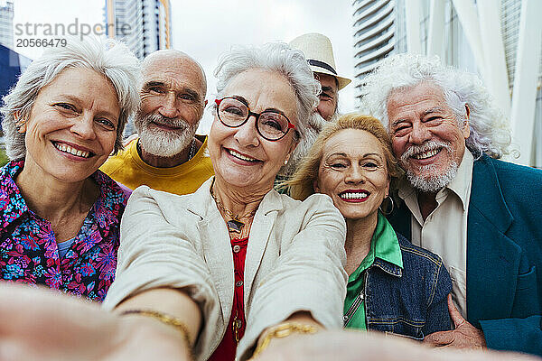 Happy elderly friends taking selfie together