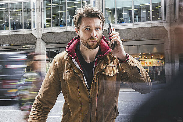 Alert tourist with smart phone standing on street