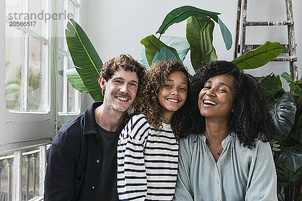 Happy family standing in winter garden smiling at camera