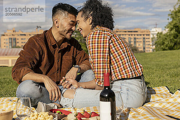 Happy boyfriend and girlfriend spending leisure time at park