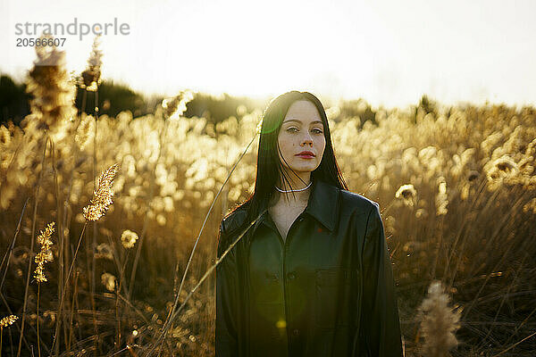 Beautiful woman standing in reeds on sunny day