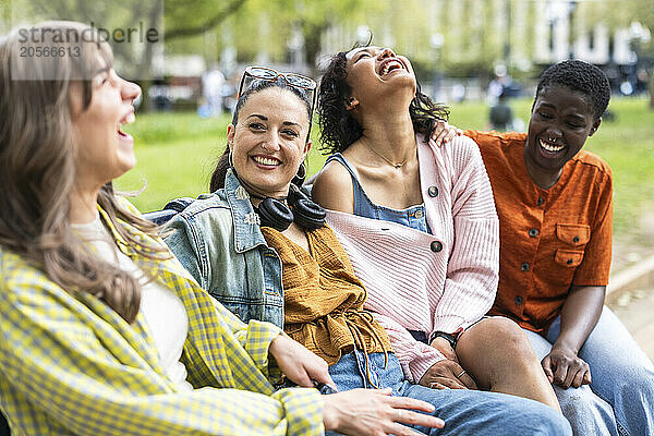 Cheerful multiracial female friends sitting together and laughing