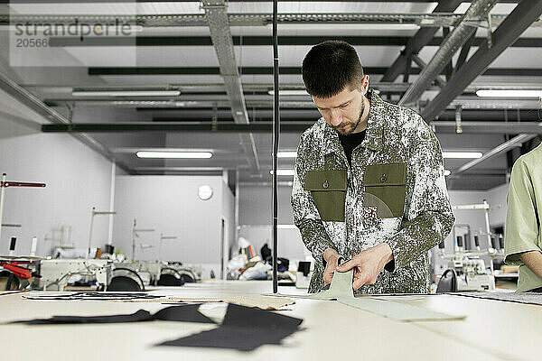 Fashion designer working with sample material at workshop