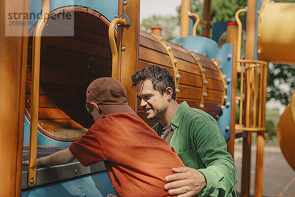 Father encouraging son to play at playground