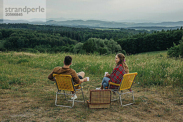 Young couple sitting on chair and spending leisure time on mountain in Poland