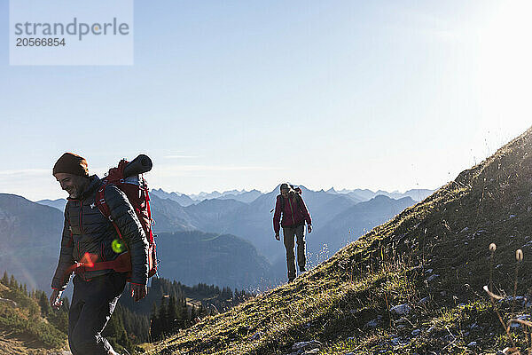 Happy man hiking with girlfriend on mountain of Tyrol in Austria