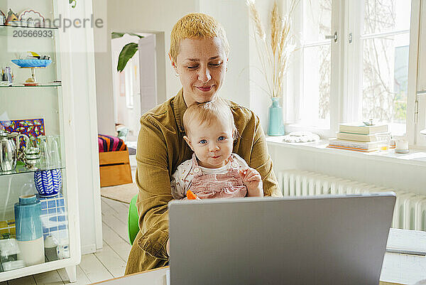 Working mother with toddler daughter at home