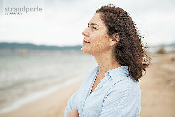 Thoughtful woman standing at beach