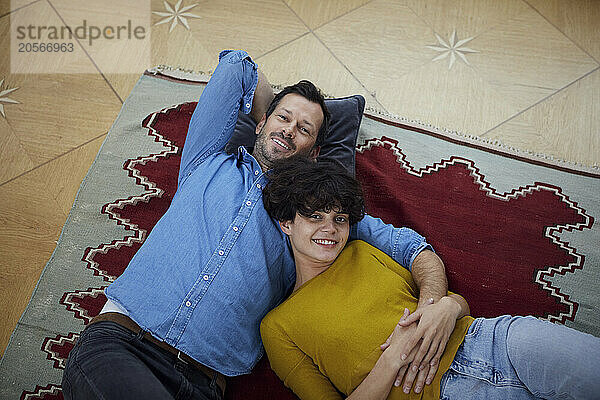 Happy couple lying on floor at home