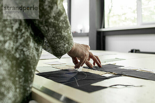 Fashion designer marking on fabric at workshop