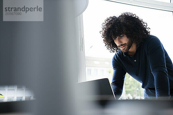 Confident businessman using tablet PC at office