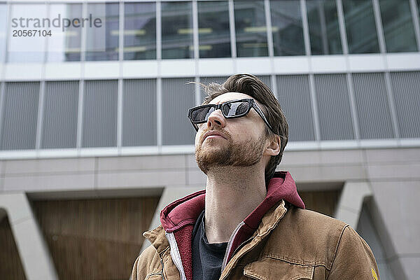 Handsome man wearing sunglasses in front of building