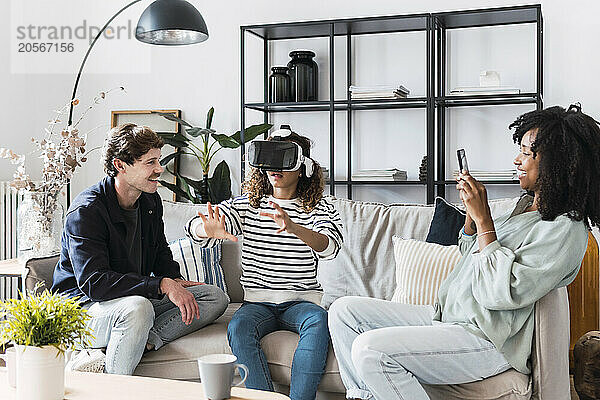 Family sitting on couch mother taking pictures of daughter using virtual reality simulator