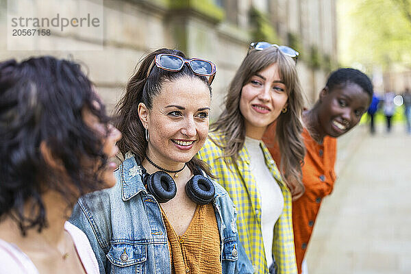 Smiling woman standing amidst friends