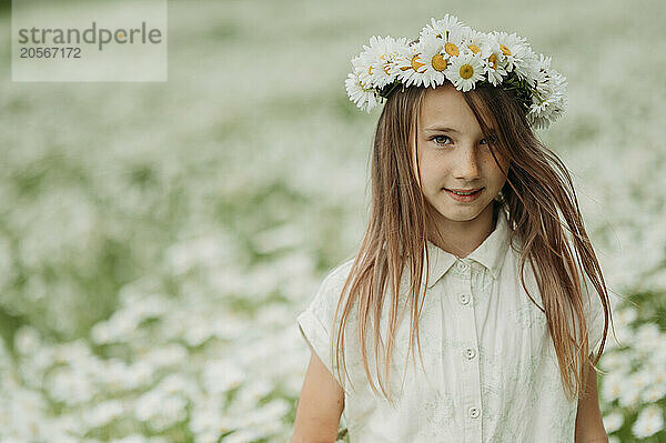 Girl wearing fresh daisy flower wreath on head