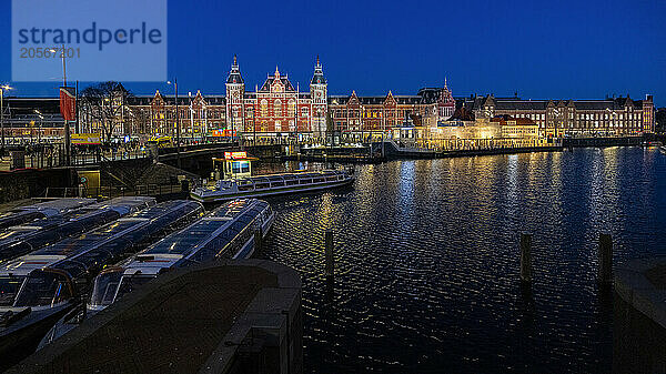 Amsterdam Centraal Railway Station near Amstel river at blue hour