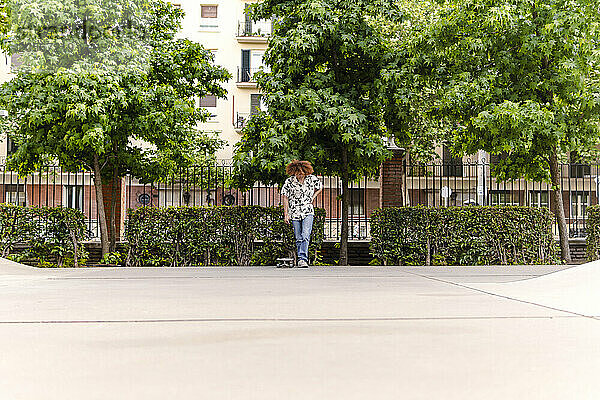 Man standing by trees in skateboard park