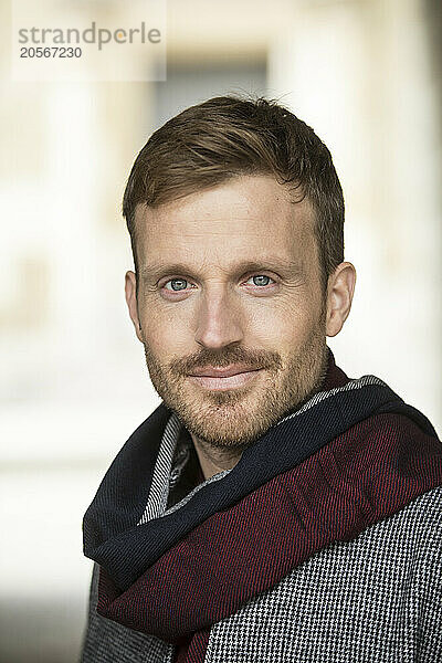 Handsome man with hair stubble and wearing scarf