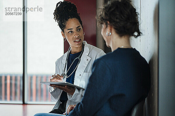 Doctor with tablet PC explaining patient in hospital