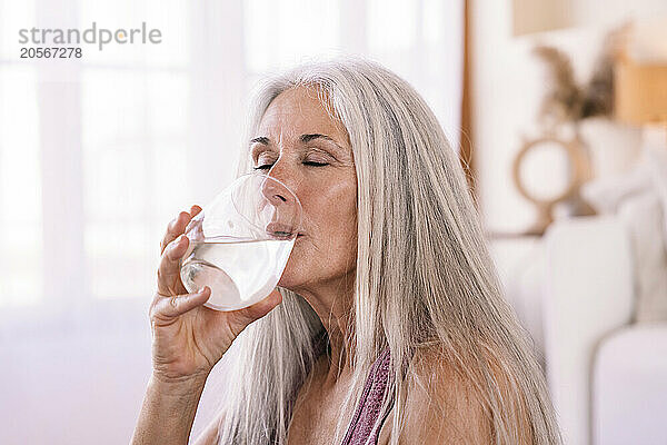 Woman with eyes closed drinking water