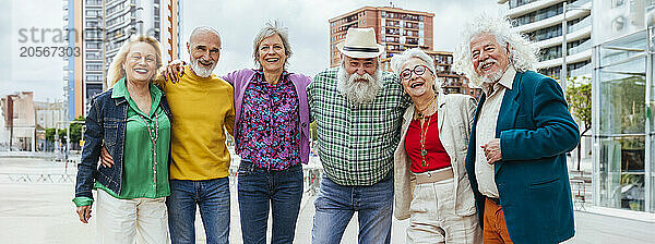 Happy elderly friends spending leisure time together in city