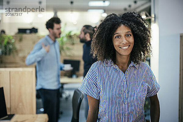 Beautiful woman standing near colleagues at cafe