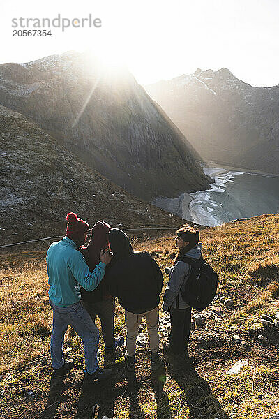 Friends standing on cliff at Lofoten and Nordic islands in Norway