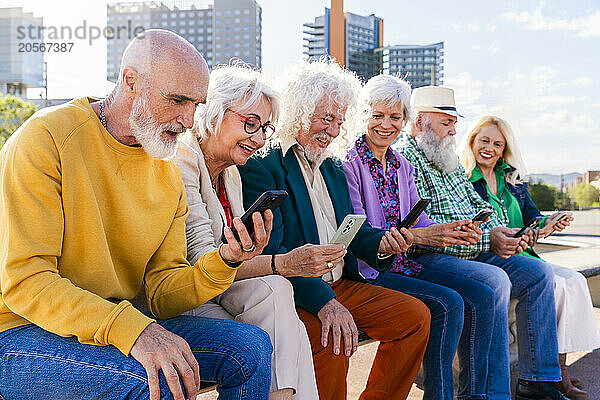 Women and men using smart phones sitting together