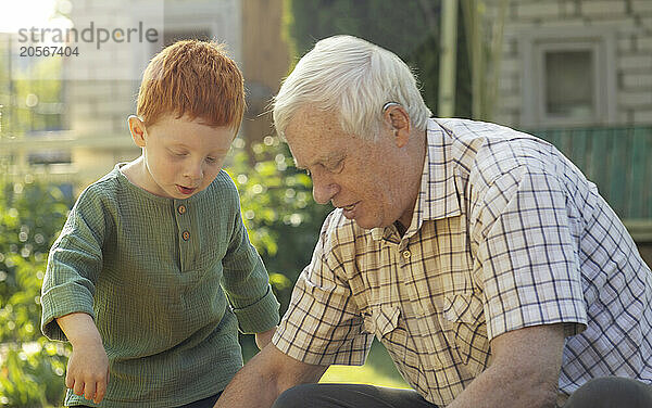 Grandfather playing with grandson at back yard