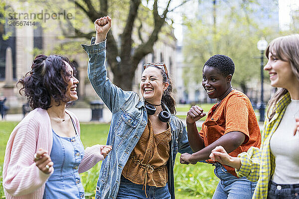 Carefree multiracial friends dancing at park