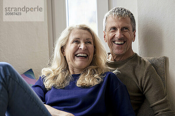 Cheerful retired senior couple relaxing at home