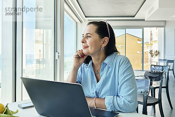 Thoughtful businesswoman with hand on chin at office