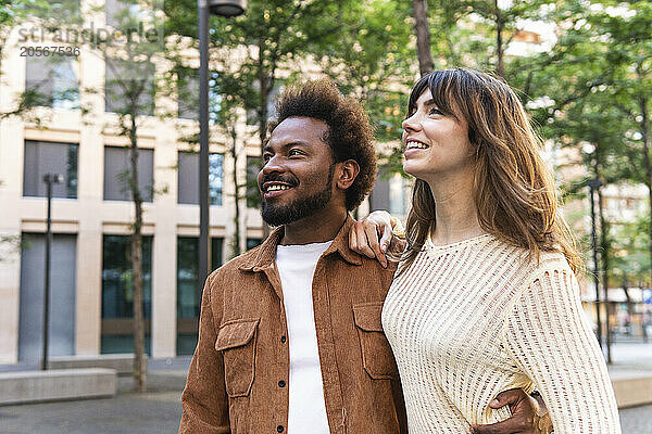 Smiling woman and man walking with arms around