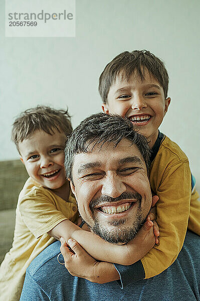 Happy father having fun with children at home