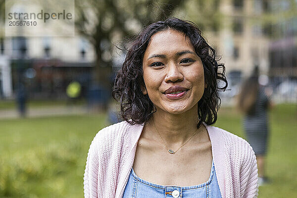 Smiling woman wearing sweater at park