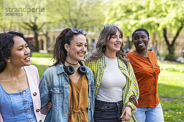 Happy multiracial female friends walking side by side