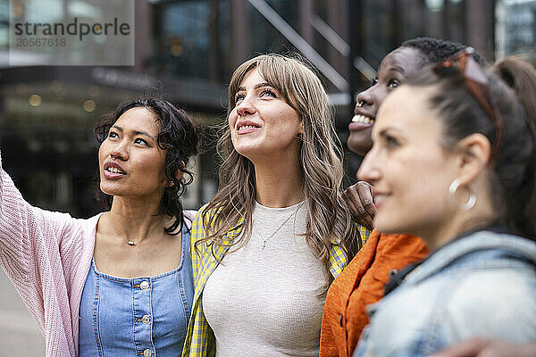 Multiracial female friends looking up