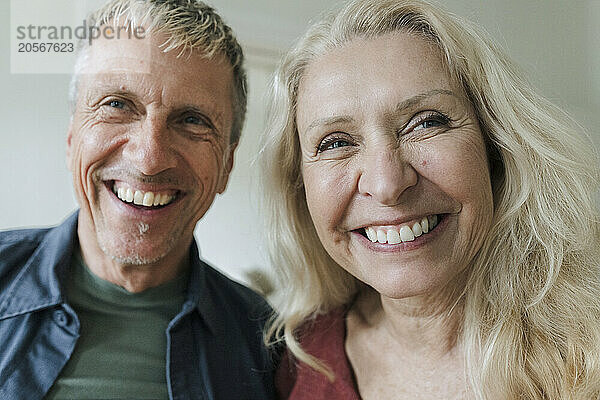 Cheerful retired senior couple looking away