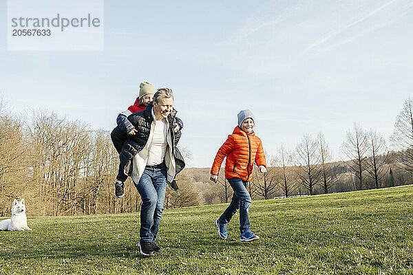 Father spending leisure time with sons in meadow