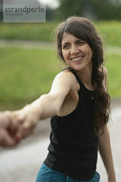 Smiling woman with long hair holding hand of man