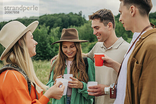 Happy group of friends having coffee on mountain in Poland