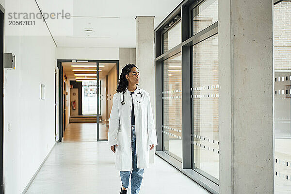 Young female doctor walking in hospital corridor