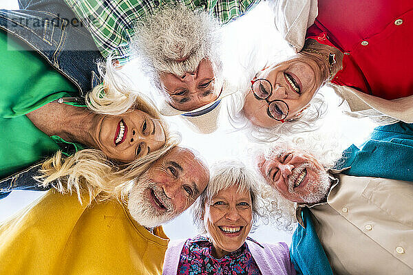 Cheerful elderly friends huddling together