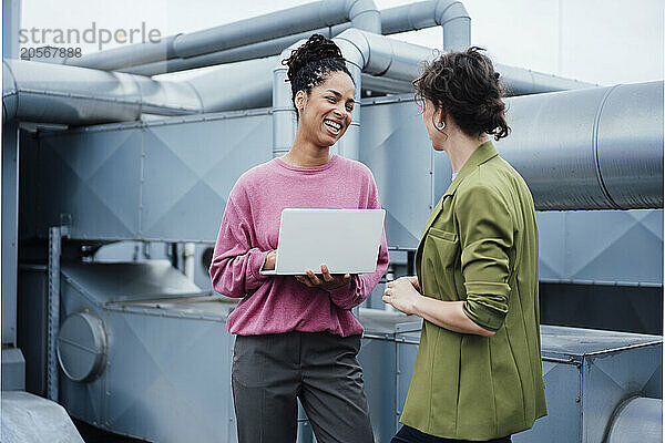 Happy businesswoman discussing with manager at industry