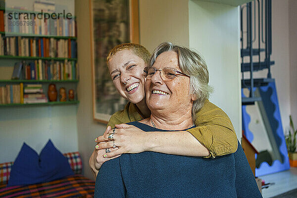 Happy woman embracing senior mother at home