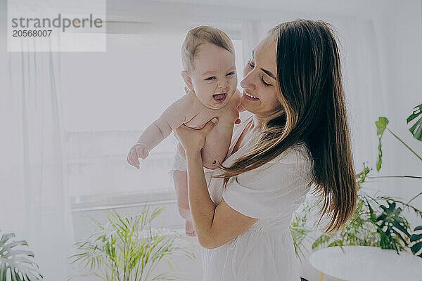 Happy mother spending leisure time with son at home